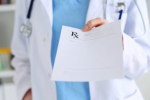 Medicine doctor hand giving prescription list to patient closeup