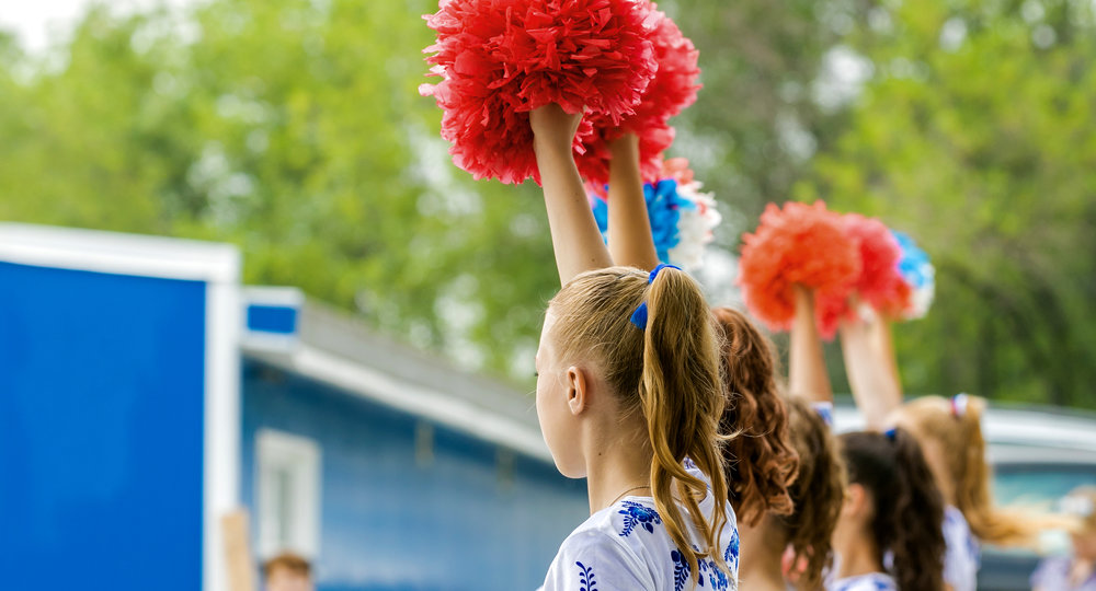 group of young girls cheerleader with red pom-poms
