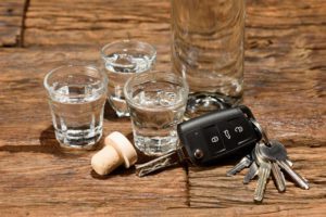 Shot glasses and a car key on an old wooden table
