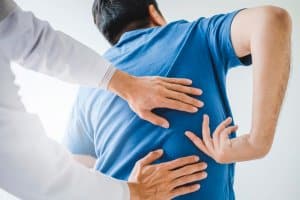 Person with back injury gets assessment from medical professional
