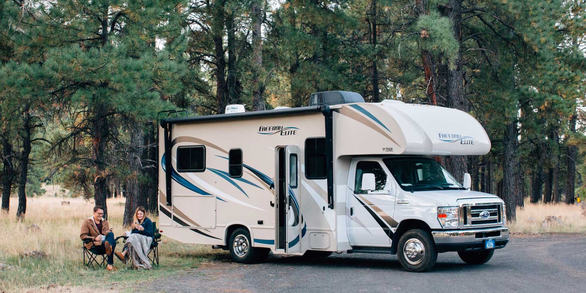 People sitting next to an RV